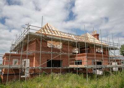 A progress photo of a new build home with timber roof trusses